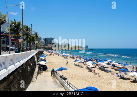 People enjoying sun, beach and blue water at Porto da Barra Beach next the Barra Lighthouse in Salvador Bahia Brazil. February, 22nd, 2019 Stock Photo