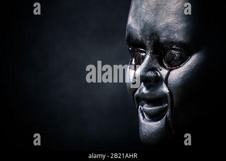 Creepy bloody doll head in the dark Stock Photo