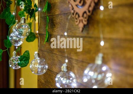 Decorative light bulbs-garlands on the background of a wooden wall. Stock Photo