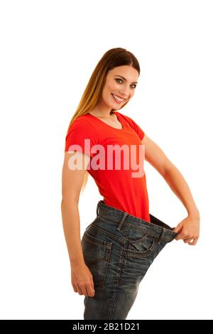 beautiful young woman holds too big trousers as she lost weight Stock Photo