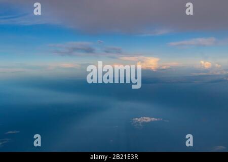 Misty sunset skies over Swedish coastline of Baltic Sea seen from a flying plane to Scavsta Airport just after a summer storm passing Stock Photo