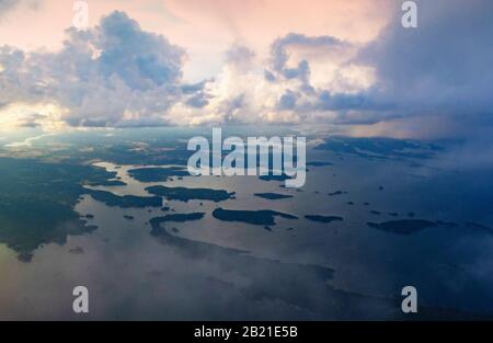 Dramatic sunset skies over Swedish coastline of Baltic Sea seen from a flying plane to Scavsta Airport just after a summer storm passing Stock Photo