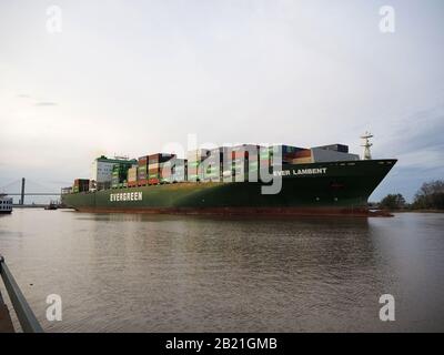 SAVANNAH, GA - FEBRUARY 23, 2020:  A very large cargo ship loaded with shipping containers, some labled China Shipping, exits the port of Savannah on Stock Photo