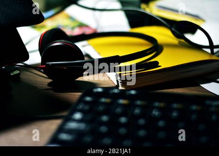 Messy desktop with headset and keyboard Stock Photo