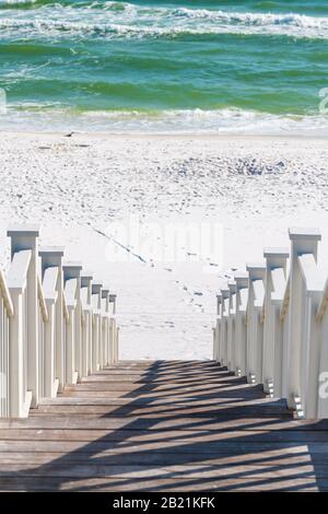 Seaside, Florida railing wooden stairway walkway steps vertical view of architecture by beach ocean background view down during sunny day Stock Photo