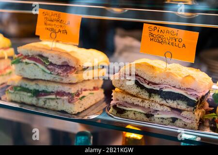 Display closeup of bread with mozzarella and prosciutto panini sandwich for lunch in shop store in Florence, Italy market Stock Photo