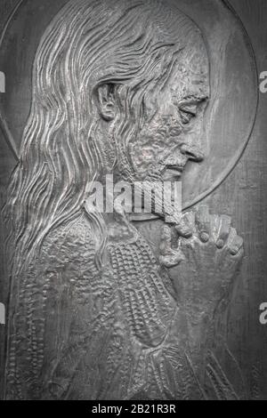 Bas-relief of Jesus with hands clasped. High relief face of Jesus Christ. Stock Photo