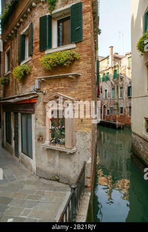 A triangular shaped building between an alley and a small back canal; Stock Photo