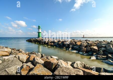 The green and red lighthouses are in view along the rocky coastline of the Northern Baltic Sea at Warnemunde Rostock, Germany, on a summer day. Stock Photo