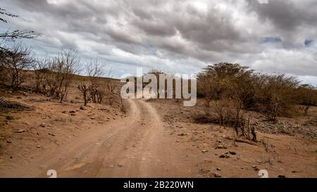 Dramatic landscape of a dirt road under the cloudy sky in the middle of the desert in Boa Vista, Cape Verde Stock Photo