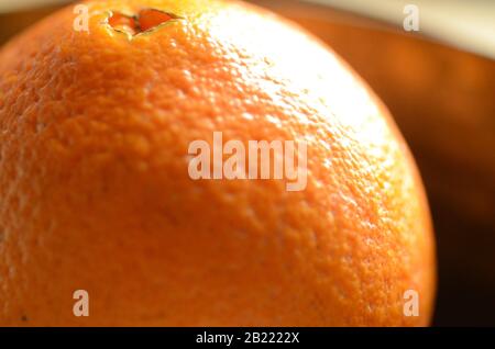 VITAMIN C: A closeup of an orange in a bowl.