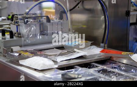 Linear tray food heat sealing and packaging machine Stock Photo