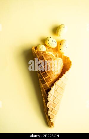 Easter card concept with waffle cone with eggs on rustic wooden ...