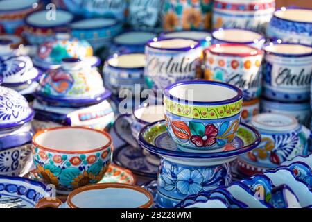 Colorful traditional Mexican pottery. Talavera style. Souvenirs on sale in local market of Puebla, Mexico. Stock Photo