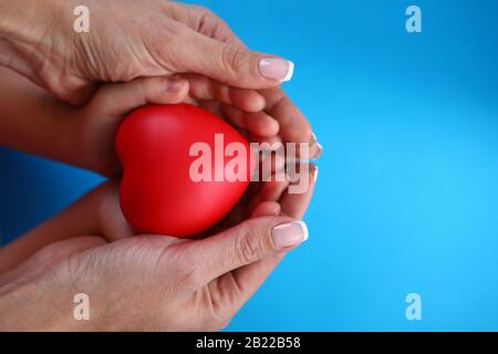 Close-up in female palms childrens hands and heart