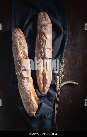 Top view of delicious long baguettes on dark table Stock Photo