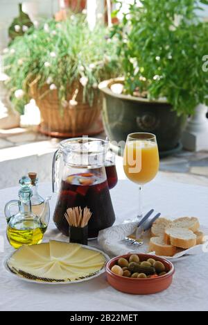 A selection of tapas with a jug of Sangria and orange juice, Sliced Manchego cheese, and green olive cocktail, Costa del Sol, Malaga Province, Andaluc Stock Photo