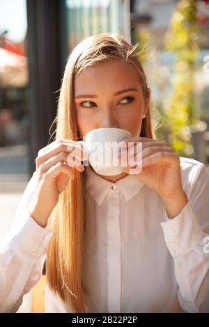 Business woman has a coffee break and drinks coffee in a bar Stock Photo