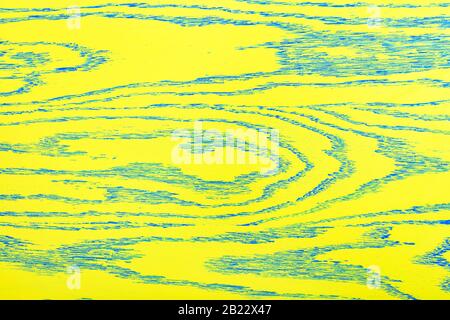 The bright yellow color of the wooden texture of the old painted board with embossed blue veins over the entire surface. Stock Photo