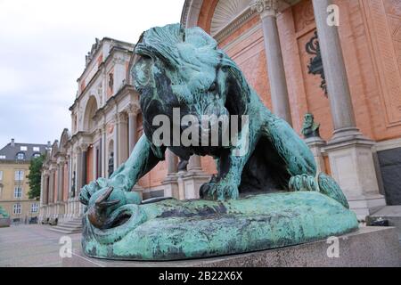 Bronze statue of a lion fighting against a snake in front of Ny Carlsberg Glyptotek in Copenhagen, Denmark Stock Photo