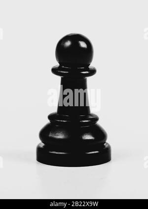 Single shiny black chess pawn isolated, matte, low contrast. One lonely chess piece on grey background, macro, closeup abstract. Game of chess univers