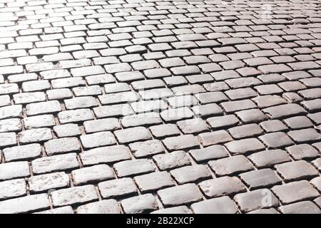Simple grey convex square stone pavement surface, paving, causeway outdoors background texture, light reflections Sidewalk, promenade cobblestone Stock Photo