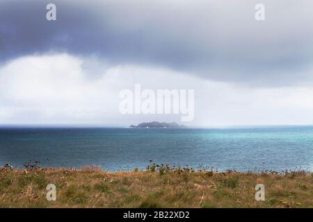 A summer storm rolls in over Gulland Rock, view from Cataclews Point above Harlyn Bay surfing beach in North Cornwall, UK. Stock Photo