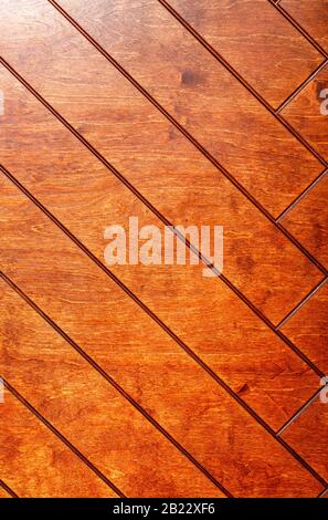Rectangular boards are painted in orange and neatly laid out with a herringbone pattern, vertical image. Stock Photo