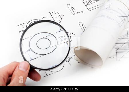 Man examining scientific papers, physics documentation fiber optics, looking at it using magnifying glass, holding loupe in hand white background Stock Photo
