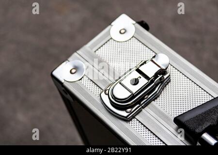 Silver metal suitcase, box, crate or simple case with a handle for equipment, valuables or money secure transport closeup. Safe storage abstract Stock Photo