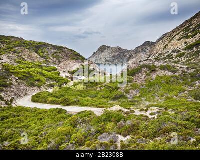 Beautiful wilderness landscape between green vegetations, hills and cliffs at San Pietro island at Cala Fico bay in Sardinia region, Italy holidays Stock Photo