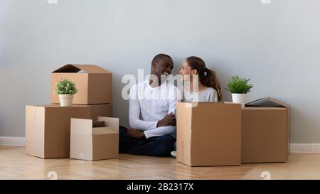 African American loving couple sitting on floor in new apartment Stock Photo