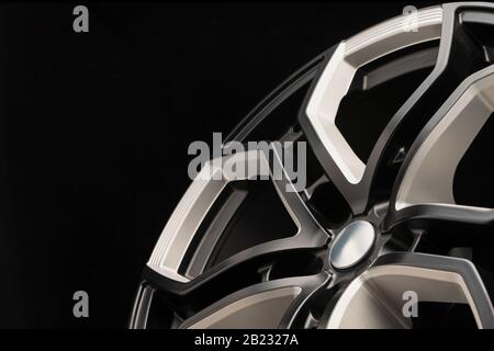 aluminum alloy wheel. Premium cast, the design of the spokes and the wheel rim, a white and black elements on dark background close-up. Stock Photo