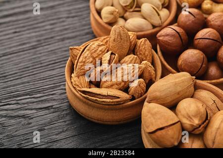 set of nuts in a bowl on black wooden background Stock Photo