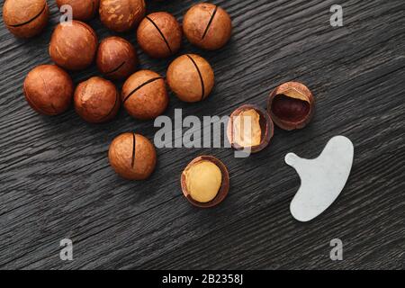 Macadam nut close-up on a black wooden background Stock Photo