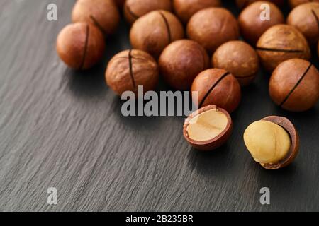 Macadam nut close-up on a black stone background Stock Photo