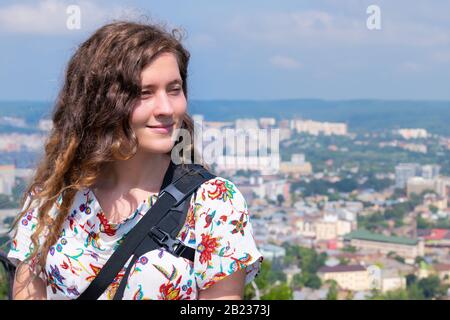 Lviv, Ukraine and young woman tourist looking at cityscape skyline in historic Ukrainian city old town buildings architecture during sunny summer day Stock Photo