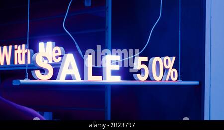 neon sign sale in the shop window at night on the street, cyber Monday and black Friday sale concept Stock Photo