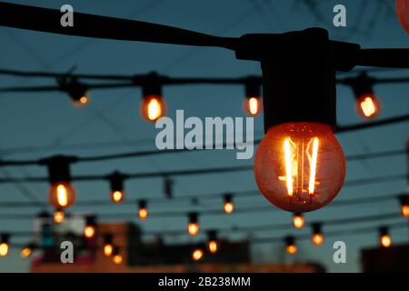 Light bulbs on the evening blue sky. Stock Photo