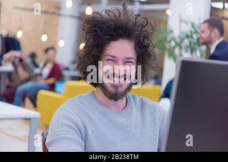 Young male web developer smiling at work while the Group of a young business multiethnic people brainstorming and discussing business plan on meeting Stock Photo