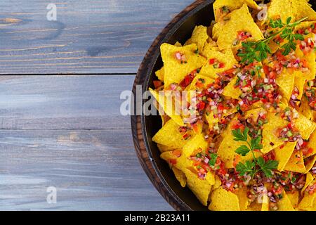 Mexican nachos with cheese. Corn chips with guacamole, salsa and tomato ketchup. Stock Photo