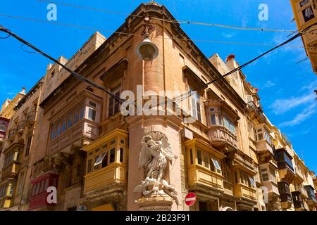 The traditional Maltese street with corners of houses, decorated with statues of saint in Valletta, Capital city of Malta Stock Photo