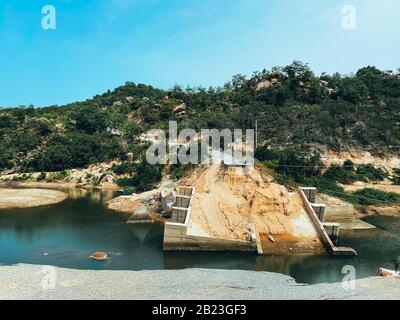 The destroyed bridge over the mountain river. Concrete bridge collapsed after the flood. Fallen bridge piers. A river in the mountains. Element. End o Stock Photo