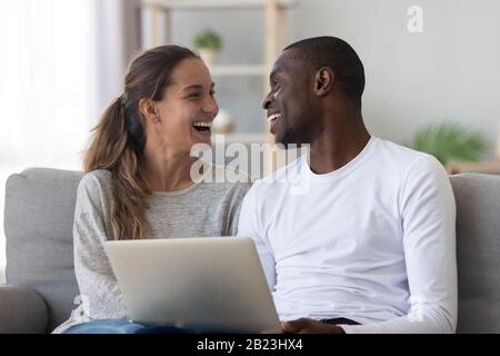 Happy African American couple having fun, using laptop Stock Photo