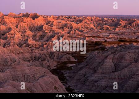 SD00253-00...SOUTH DAKOTA - Sunset painting the buttes orange along the Sage Creek Rim Road in Badlands National Park. Stock Photo