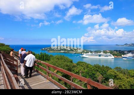 Castries, Saint Lucia - November 23, 2019. Taxi driver/Tour operator with shirt on pants accompanies tourist from a cruise ship in the harbor Stock Photo