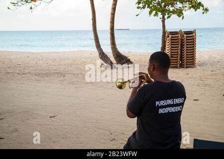 young man trumpeter playing the trumpet wearing a shirt - protecting the environment- 'pursuing energy independence' Stock Photo
