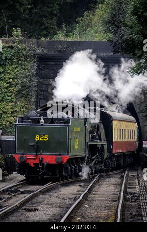 The 825 steam locomotive entering a tunnel at Grosmont rail station, hauling passenger carriages on the NYMR (North Yorkshire Moors Railway) in North Stock Photo