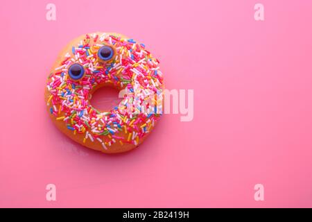 close up of donuts with funny face on color background . Stock Photo