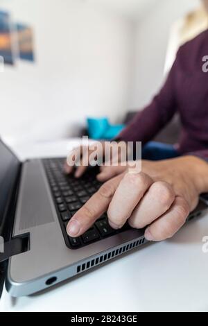 Quit my job concept. Low angle view of a man pressing the escape button on a laptop keyboard. Stock Photo
